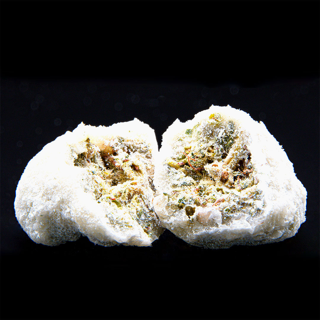 CBD Ice Rock mit weißer kristalliner Außenhülle und angeschnittener Blütenstruktur auf schwarzem Hintergrund