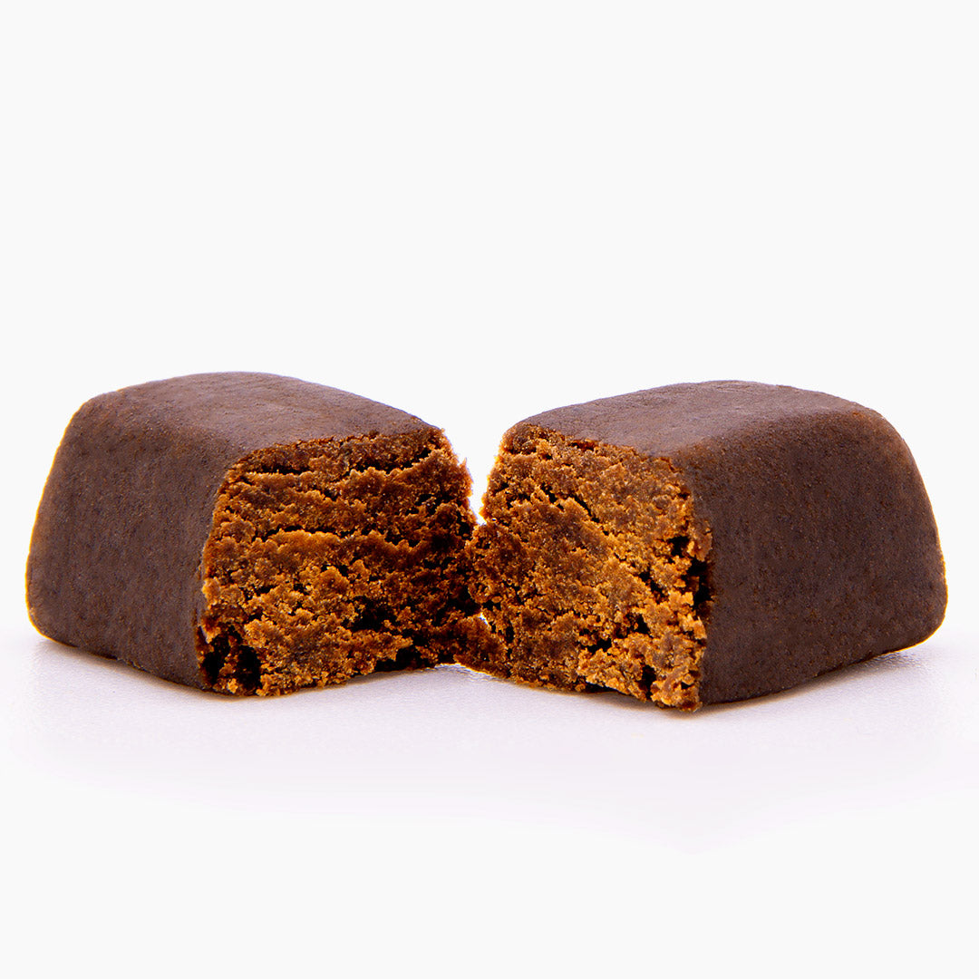 CBD Maroc Hash Block mit angeschnittener Mitte und goldbrauner, leicht krümeliger Innenstruktur auf hellem Hintergrund